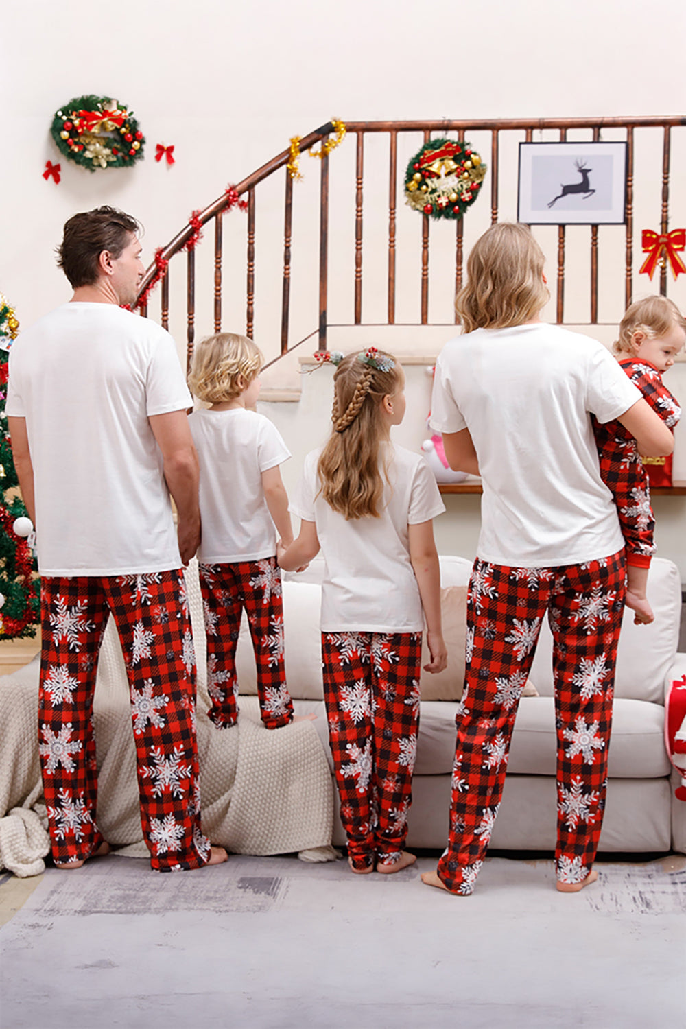 Familj matchande julpyjamas med röd pläd