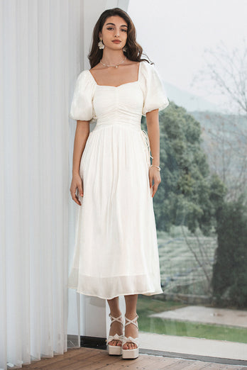 En linje plisserad liten vit klänning med puffärmar