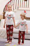 Familj matchande julpyjamas med röd pläd